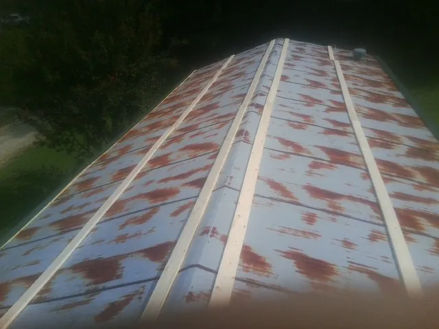 Rusted metal roof panels with new wood purlins before replacement — Storm Damage Roof Repair in Fairview by Roofing Brothers